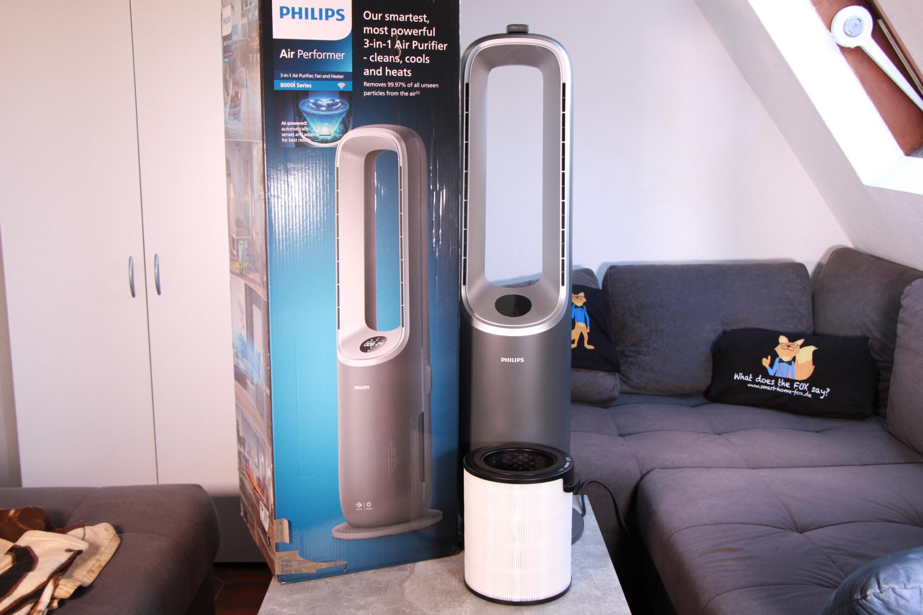 Der Philips Air Performer Series 8000 (AMF870/15) steht auf einem Couchtisch neben dem Karton.